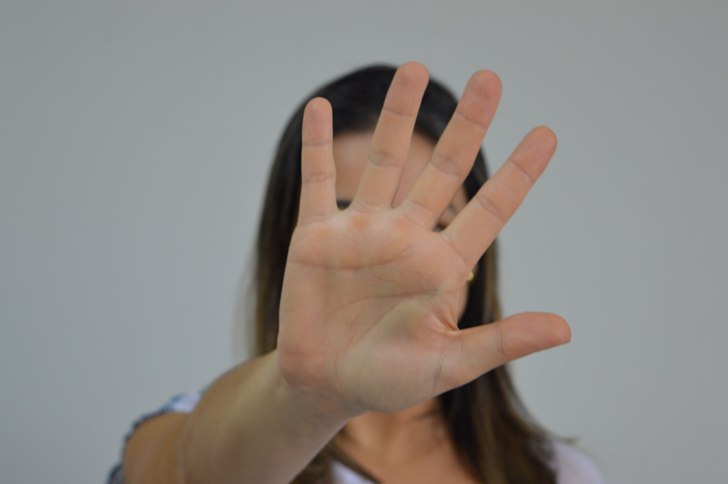 Mulher faz gesto de "basta!" com a mão