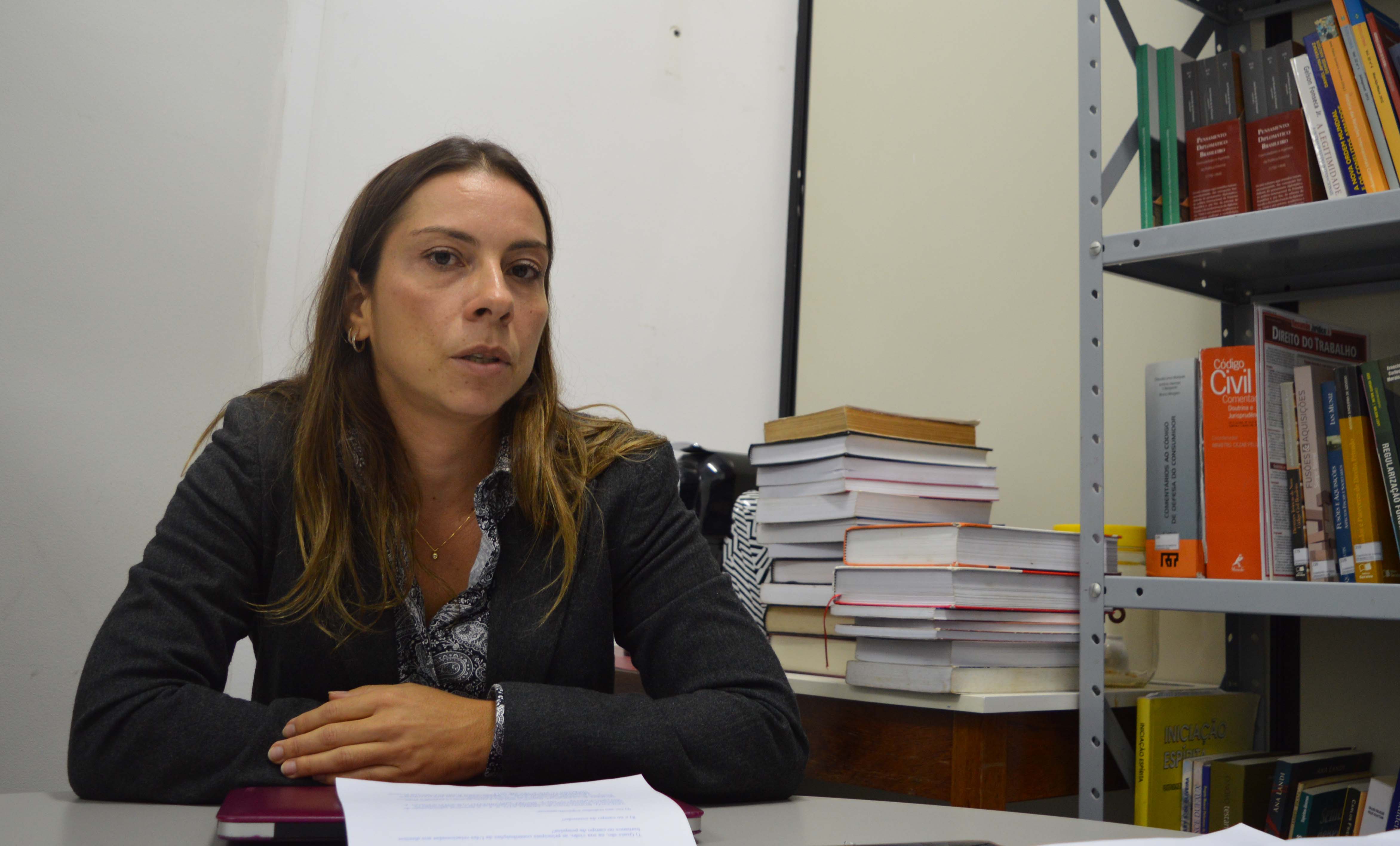 Professora de Direito Brunela Vicenzi e fundo com livros