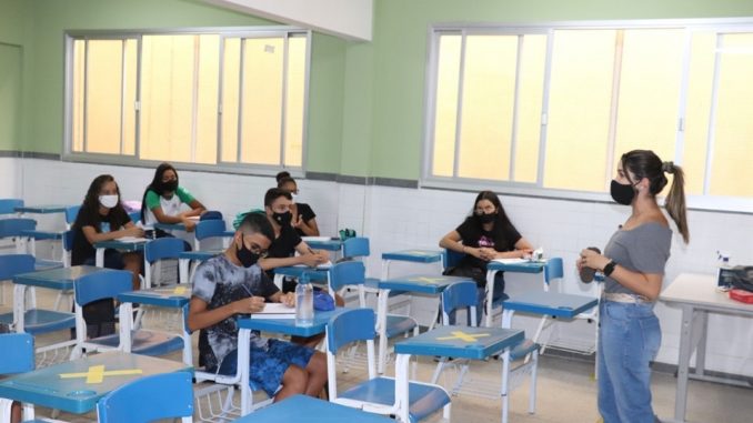 Sala de aula de escola capixaba, com professora e alunos de máscara e cumprindo distanciamento social